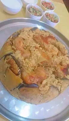 a plate of food with rice on a table at المزار لوج in Al Mazār