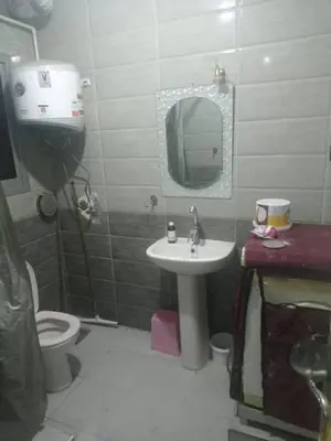 a bathroom with a sink and a toilet and a mirror at المزار لوج in Al Mazār
