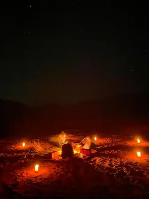a group of people laying on the beach at night at Wadi Rum Cave Experience in Wadi Rum