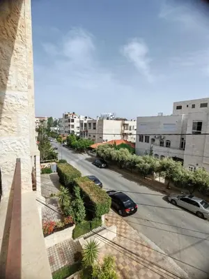 a view of a street with cars parked on the road at Khalda One Bedroom Apt in Amman
