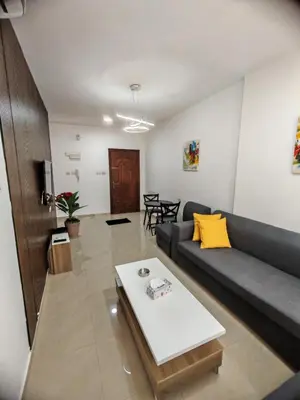 a living room with a couch and a table at Khalda One Bedroom Apt in Amman