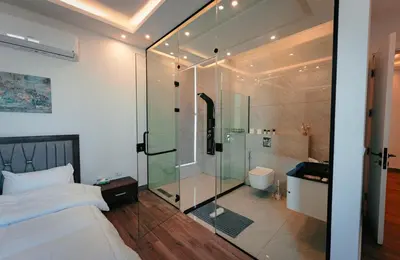 a bedroom with a glass shower and a bed at Bow Villa in Sowayma