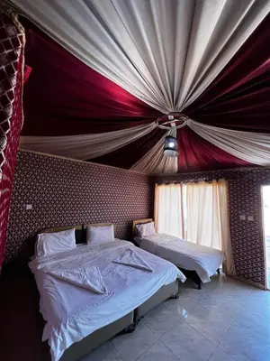 a bedroom with two beds and a ceiling at Wadi rum camp hamod in Wadi Rum