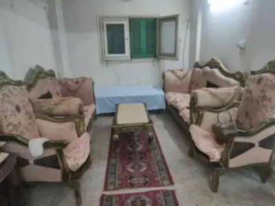 a living room with three couches and a table at هيوم شليت in Um Qeis