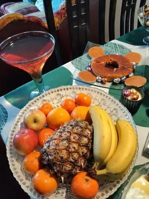 a plate of fruit on a table with a drink at هيوم شليت in Um Qeis