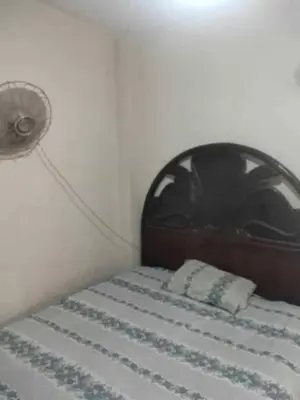 a bed with a wooden headboard and a white mattress at هيوم شليت in Um Qeis