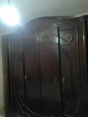 a dark wooden cabinet with a light on top at هيوم شليت in Um Qeis