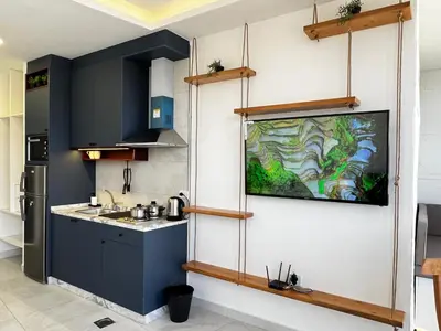 a kitchen with blue cabinets and a painting on the wall at Central Amman Stunning Views Apt in Amman