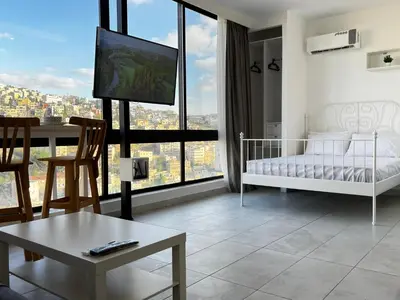 a living room with a crib and a tv in it at Modern Studio Apartment Near Downtown, breathtaking view! in Amman