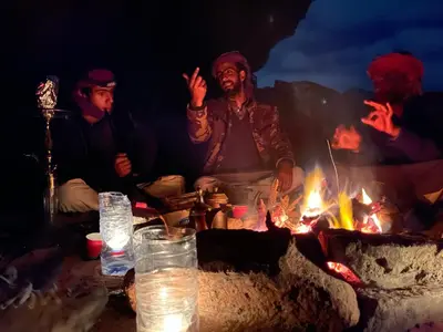 a group of men sitting around a campfire at Wadi Rum Starlit in Wadi Rum