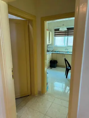 an open door to a kitchen with a table at Al-Amer شقق الخامسه الراقيه in Aqaba