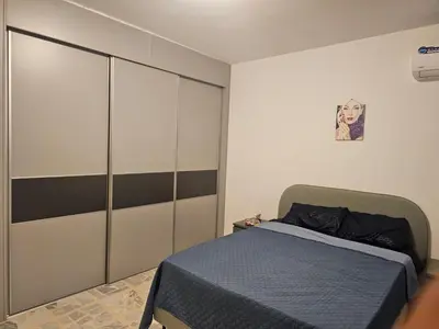 a bedroom with a bed and a large wardrobe at شقة 3غرف نوم في ضاحية الرشيد in Amman