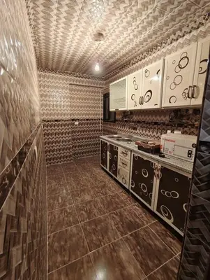 a kitchen with white cabinets and a counter top at شقه الحنان in Dayr as Si‘nah