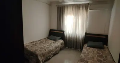 a hotel room with two beds and a window at Apartments for Rent in Irbid