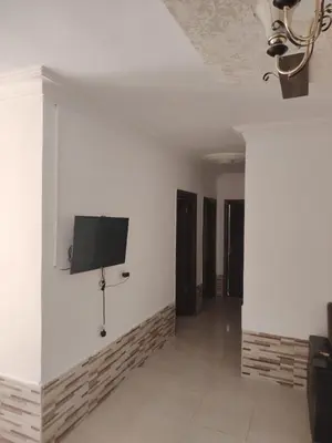 a room with white walls and a tv on the wall at Apartments for Rent in Irbid