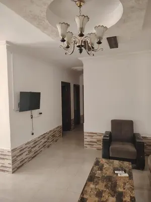 a living room with a couch and a television on a wall at الخليل 3 in Irbid