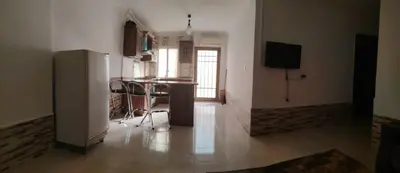 a kitchen with a refrigerator and a table in a room at الخليل 3 in Irbid