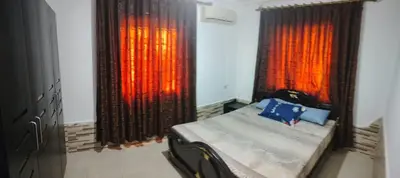 a bedroom with a bed and two large windows at الخليل 3 in Irbid