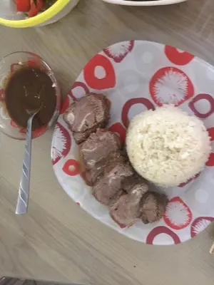 a plate of food with meat and rice on a table at الريف فيلا in Ar Ramthā