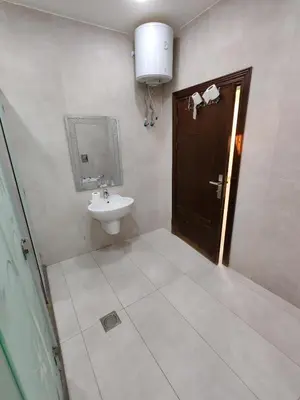 a bathroom with a sink and a mirror and a door at Wonder Villa in Al Rama