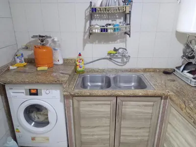 a kitchen with a sink and a washing machine at Sky2 in Jerash