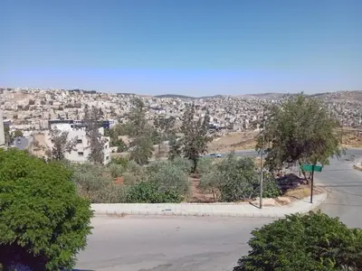 an empty parking lot with a city in the background at Sky 2 in Jerash