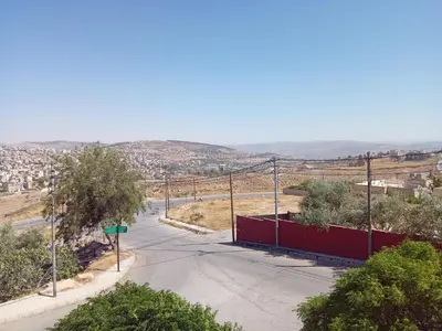 an empty road with a street sign and a city at Sky 2 in Jerash