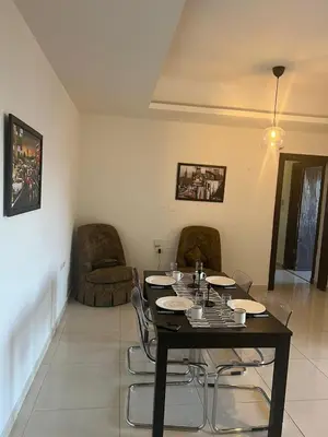 a dining room with a black table and chairs at Abdoun is comfortable accommodation and an exceptional location close to the mall in Amman