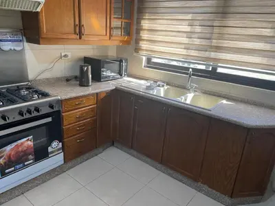 a small kitchen with a stove and a sink at Abdoun is comfortable accommodation and an exceptional location close to the mall in Amman
