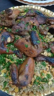 a plate of food with meat on top of rice at ranos villa in An Nu‘ayyimah