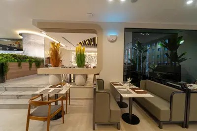 a restaurant with tables and chairs and a couch at Hill Top Hotel in Aqaba