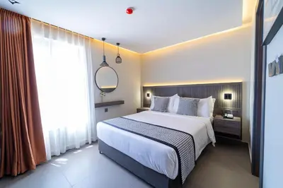 a bedroom with a bed and a large window at Hill Top Hotel in Aqaba
