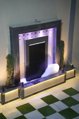 a living room with a fireplace with purple at Lumen villa in Umm Uthainah