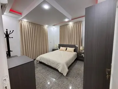 a bedroom with a bed and a cross on the wall at Raha's house in Jerash