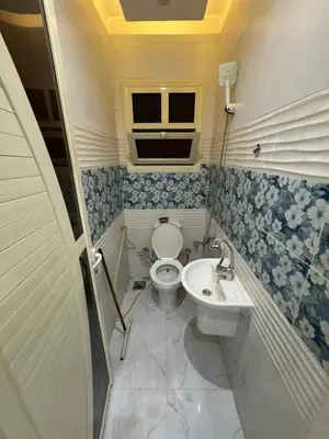 a bathroom with a toilet and a sink at النعيمه هاوس in An Nu‘ayyimah