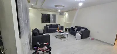 a living room with blue couches and a table at الريان غرفتين نوم in Amman