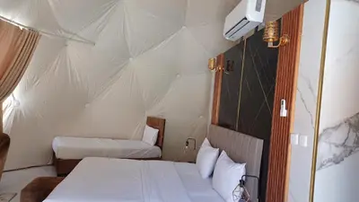 a bedroom with two beds in a tent at Tarf Wadi Rum Luxury Camp & Jeep Tours in Wadi Rum
