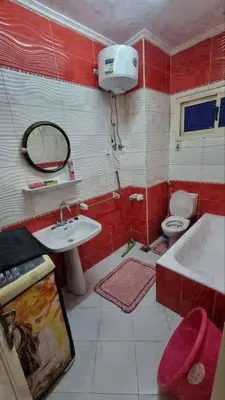 a bathroom with a sink and a toilet and a tub at ام الدنانير هاوس in Rujm al Ḩāwī