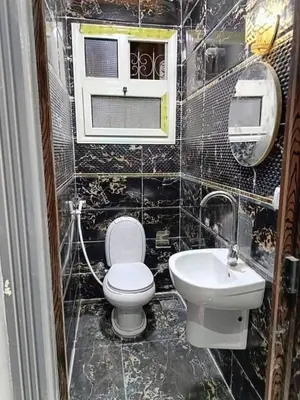 a bathroom with a toilet and a sink at ام الدنانير هاوس in Rujm al Ḩāwī