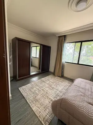a bedroom with a bed and a large mirror at Warm 1BR in Dabouq in Amman