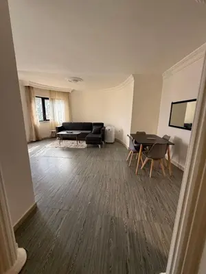 a living room with a couch and a table at Warm 1BR in Dabouq in Amman