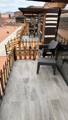 a balcony with chairs and a wooden fence at Moon Dunes Wadi Rum in Disah