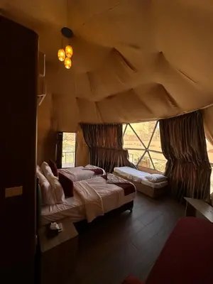 a bedroom with two beds and a window at Moon Dunes Wadi Rum in Disah