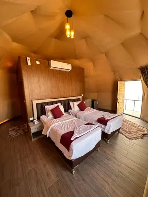 a bedroom with two beds in a room with a ceiling at Moon Dunes Wadi Rum in Disah