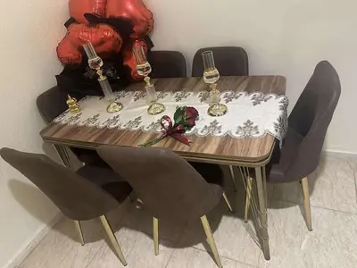 a wooden table with chairs and wine glasses on it at ام النعمان شليت in Umm as Surab