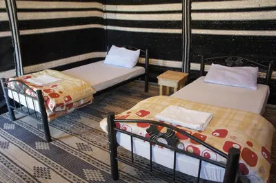 a room with two beds and a table at Dana Village lodge and Camp-Wadi Dana Eco camp in Dana