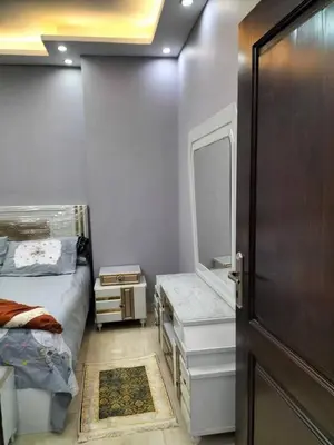 a bedroom with a bed and a mirror and a door at رحيق الزخور هاوس in Madaba