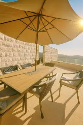 a wooden table and chairs with an umbrella at Jordan Castle Resort in Irbid