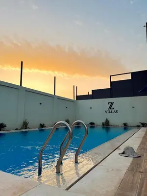 a pool with a metal sculpture in front of a building at Z villas Chalet in Al Rama