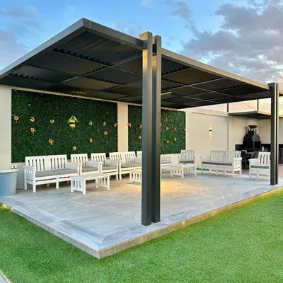 a pavilion with white tables and chairs on a lawn at Z villas Chalet in Al Rama